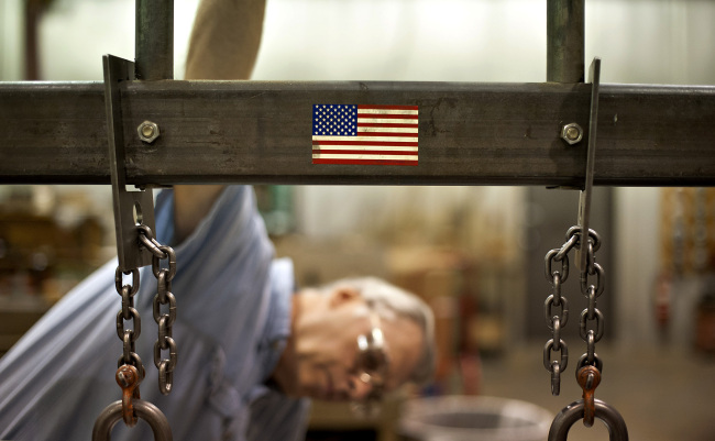Employee William Meznarich reassembles the die for a punch press at the Badge-A-Minit facility in Oglesby, Illinois, Friday.           (Bloomberg)
