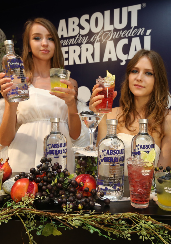 Models showcase the Absolut Berri Acai, a liquor product featuring a blend of pomegranates, blueberries and acai berries, from France-based Pernod Ricard at a launch ceremony in downtown Seoul on Tuesday.  (Pernod Ricard Korea)