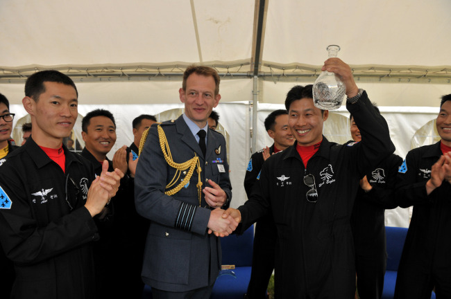 Station commander of Waddington Royal Air Force Base, Gp. Capt. Al Gillespie (second from left), and commander of the Black Eagles Lt. Col. Kim Young-hwa shake hands at the air force base in the U.K. on Monday.  (Air Force)