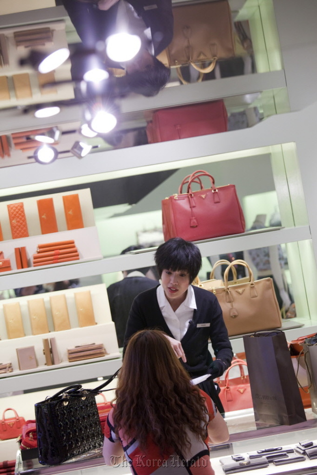 A Prada sales assistant attends to a customer in Hong Kong.   Bloomberg