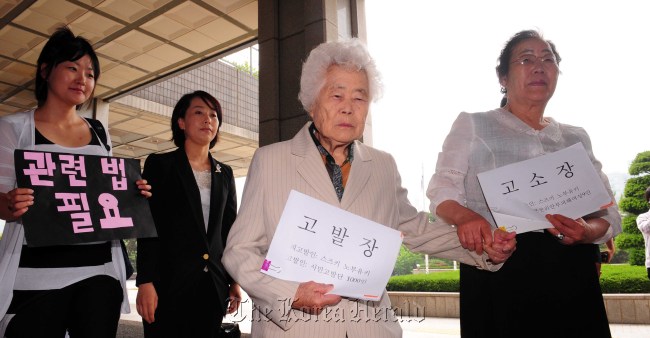 Two victims of Japan’s wartime sex slavery enter the Seoul Central District Prosecutors’ Office on Wednesday to submit a lawsuit against Japanese rights activist Nobuyuki Suzuki.  (Lee Sang-sub/The Korea Herald)