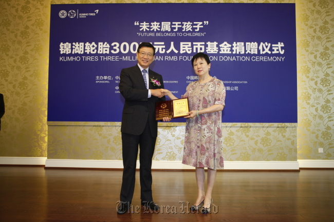 Kumho Asiana Group chairman Park Sam-koo (left) shakes hands with Li Xiaolin, president of the Chinese People’s Association for Friendship with Foreign Countries, after donating 3 million yuan ($473,000) for the education of disabled children in Beijing and Nanjing in the coming five years.  (Kumho Asiana Group)