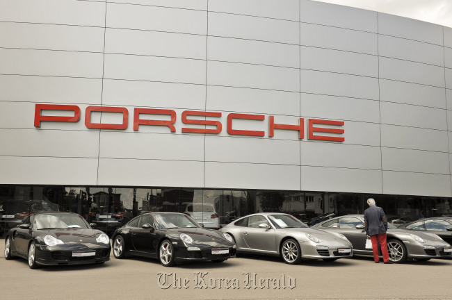 A customer browses Porsche 911 automobiles on display outside a dealership in Stuttgart.  Bloomberg