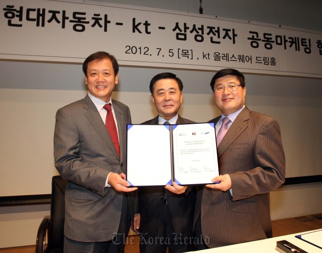 Samsung Electronics’ business-to-business sales chief Park Eun-soo (left), Hyundai Motor’s domestic sales head Kwak Jin (center) and Im Heon-moon, home customer business chief of KT Corp., pose after signing an agreement for joint marketing activities at KT’s headquarters in Seoul on Thursday.  (Hyundai Motor)