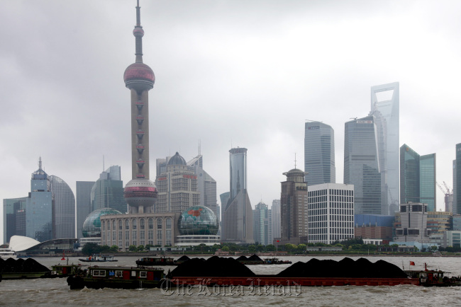 Barges on the Huangpu River loaded with coal steam past the skyscrapers of Lujiazui financial district in Shanghai.  Bloomberg