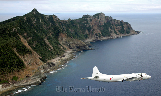 Japan Maritime Self-Defense Force's P-3C Orion surveillance plane flies over the disputed islands in the East China Sea, called the Senkaku in Japan and Diaoyu in China, Oct. 13, 2011. (AP-Yonhap News)