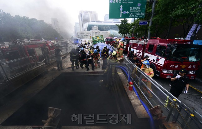 9일 출근시간대인 8시45분경 서울 시청역 7번출구 앞 지하철 터파기 공사구간에서 원인미상의 화재가 발생해 검은연기가 시청인근을 뒤덮고 교통체증을 유발했다. 신속히 출동한 소방대원들이 진화작업을 펼치기 위해 화재현장으로 들어가고 있다. 박해묵 기자/mook@heraldm.com
9일 출근시간대인 8시45분경 서울 시청역 7번출구 앞 지하철 터파기 공사구간에서 원인미상의 화재가 발생해 검은연기가 시청인근을 뒤덮고 교통체증을 유발했다. 신속히 출동한 소방대원들이 진화작업을 펼치기 위해 화재현장으로 들어가고 있다. 박해묵 기자/mook@heraldm.com