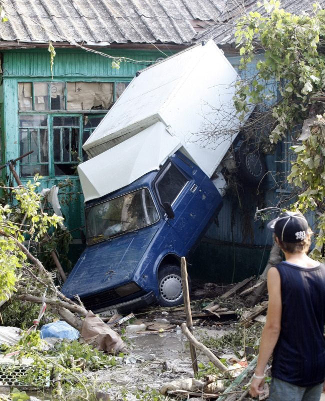 Damaged car stuck in a flooded street in the town of Krymsk.  (ITAR-TASS-Yonhap News)