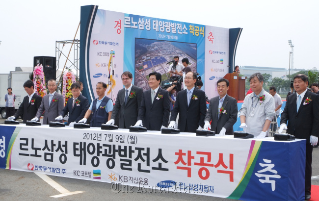 Renault Samsung Motors CEO Francois Provost (fifth from left) and other participants celebrate the ground-breaking of a solar power plant at the company’s Busan factory on Monday.   RSM