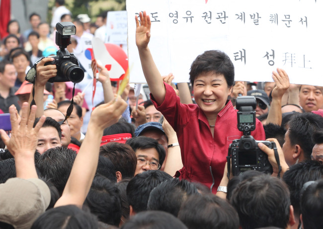 <YONHAP PHOTO-0505> 박근혜, 대선출마 공식선언 (서울=연합뉴스) 김주성 기자 = 새누리당 유력 대선주자인 박근혜 전 비대위원장이 10일 오전 영등포 타임스퀘어에서 열린 18대 대통령선거 후보 출마 선언식에서 지지자들에게 손을 흔들고 있다. 2012.7.10 utzza@yna.co.kr/2012-07-10 11:22:04/ <저작권자 ⓒ 1980-2012 ㈜연합뉴스. 무단 전재 재배포 금지.>
Rep. Park Geun-hye, the ruling Saenuri Party’s former chief and leading presidential hopeful, greets her supporters at Youngdeungpo Times Square on Tuesday as she announces her bid in the December election.  Yonhap News