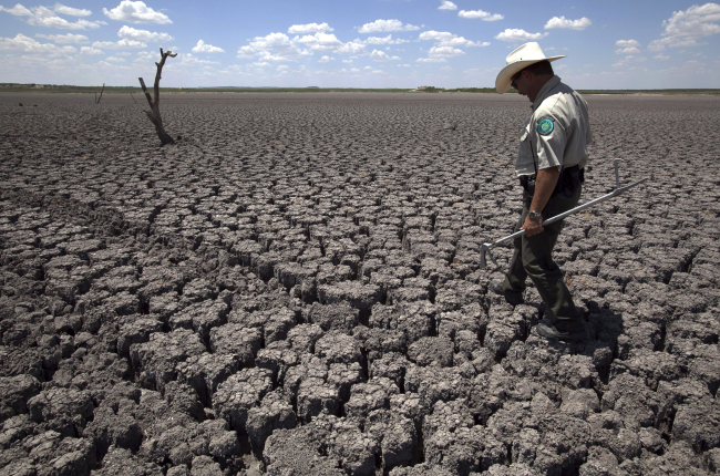 A man walks across the cracked lake bed of O.C. Fisher Lake in San Angelo, Texas.  AP-Yonhap News