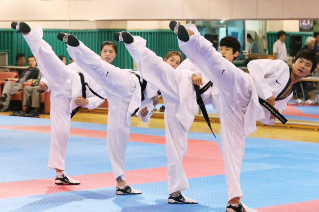 <YONHAP PHOTO-1176> 금빛 발차기 (서울=연합뉴스) 안정원 기자 = 런던올림픽을 17일 앞둔 7일 서울 노원구 태릉선수촌에서 열린 태권도국가대표팀 미디어데이에서 여자 67kg 이상급 이인종(왼쪽부터.에스원), 67kg급 황경선(고양시청) 남자 58kg급 이대훈 (용인대), 80kg 이상급 차동민(한국가스공사)이 금빛 발차기를 하고 있다. 2012.7.10 jeong@yna.co.kr/2012-07-10 16:11:36/ <저작권자 ⓒ 1980-2012 ㈜연합뉴스. 무단 전재 재배포 금지.>
The Korean national taekwondo team is looking to keep its dominance in the Olympics.  Yonhap News
The Korean national taekwondo team is looking to keep its dominance in the Olympics.  Yonhap News