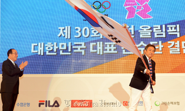 11일 오후 서울 송파구 방이동 올림픽홀에서 열린 2012 런던올림픽 선수단 결단식에서. 이기흥 대표선수단장이 박용성 대한체육회장에게 전달받은 단기를 흔들고 있다./ 안훈기자 rosedale@ 2012.07.11
GOING FOR GOLD Lee Ki-hong, the head of the Korean Olympic team, waves the national flag after it was handed over from Park Yong-sung, the president of the Korean Olympic Committee, during the Korean delegation’s inaugural ceremony for the 2012 London Olympics in Seoul on Wednesday.  Ahn Hoon/The Korea Herald
GOING FOR GOLD  Lee Ki-hong, the head of the Korean Olympic team, waves the national flag after it was handed over from Park Yong-sung, the president of the Korean Olympic Committee, during the Korean delegation’s inaugural ceremony for the 2012 London Olympics in Seoul on Wednesday.  Ahn Hoon/The Korea Herald