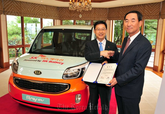 Kia Motors CEO Lee Sam-woong (right) and SK Innovation CEO Koo Ja-young pose after signing a memorandum of understanding at a Seoul hotel on Wednesday.  Kia Motors