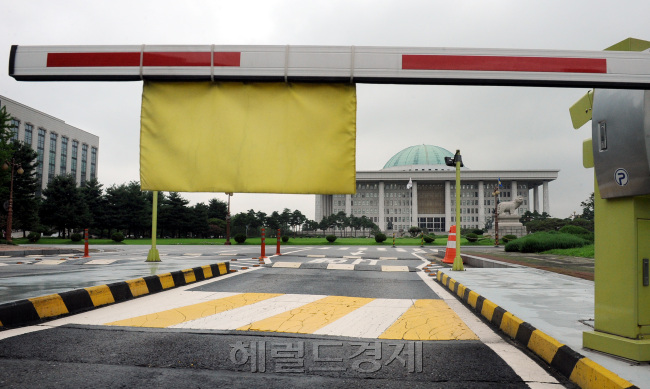 12일 오전   국회의사당. 박현구 기자phko@heraldm.com 2011.08.12
12일 오전   국회의사당. 박현구 기자phko@heraldm.com 2011.08.12
특권을 내려놓겠다고 공언했던 19대 국회가 결국 제 식구 지키기에는 한통속이었다. 정두언 새누리당 의원의 체포통의안 부결에 대한 비판이 거세지자 여야는 상대방의 잘못이라면서 책임돌리기에만 급급했다. 국회 입구에 설치된 차량 차단기가 마치 국민의 법감정에 아랑곳하지 않고 자신들의 이익만 지키는 ‘그들만의 국회’를 상징하는 것 같다.  박현구 기자/phko@