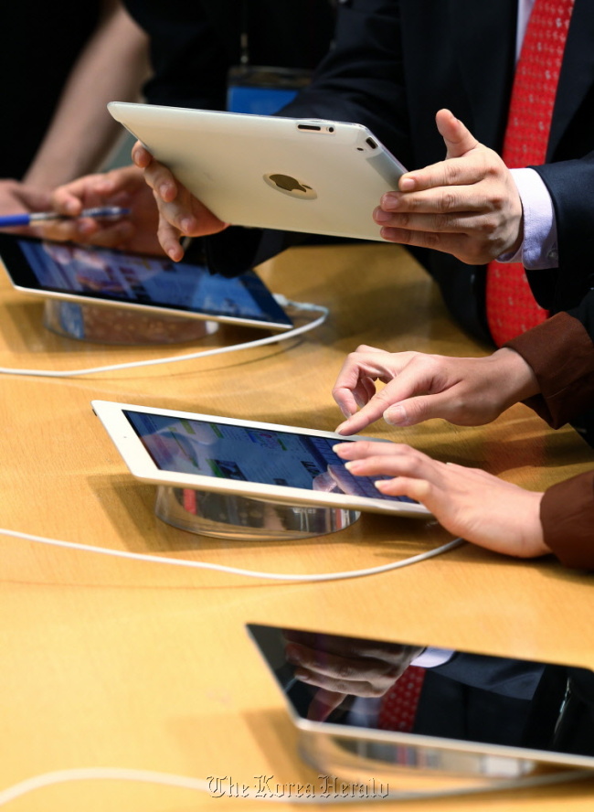 Visitors try out new iPads at an Apple Inc. store in Seoul.  Bloomberg