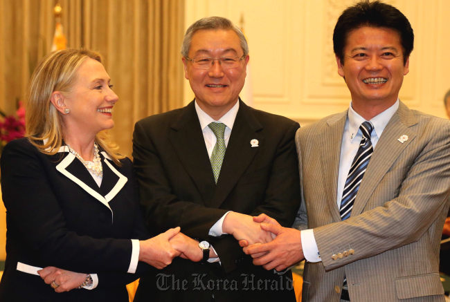 South Korean Foreign Minister Kim Sung-hwan (center) poses with U.S. Secretary of State Hillary Clinton (left) and Japanese Foreign Minister Koichiro Genba at their meeting on the sidelines of the ASEAN Regional Forum in Phnom Penh on Thursday. (Yonhap News)