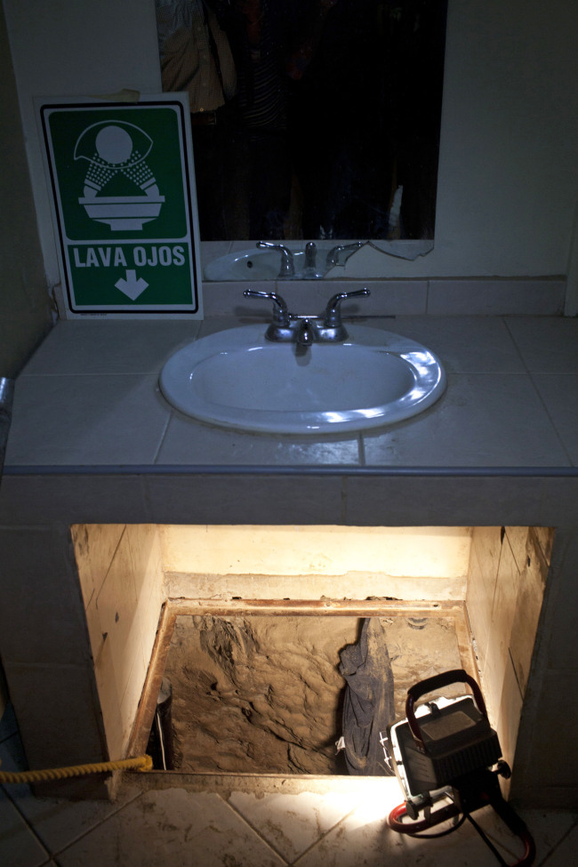 The entrance to a cross border illegal tunnel is lit by a lamp after it was found underneath a bathroom sink by the Mexican army inside a warehouse in Tijuana, Mexico.
AP-Yonhap News