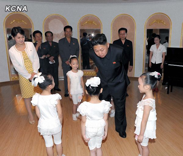 North Korea’s leader Kim Jong-un and an unidentified woman in a yellow dress talk to children during his recent visit to a kindergarten in Pyongyang. The scene was released by the Korean Central Television on Sunday.   Yonhap News