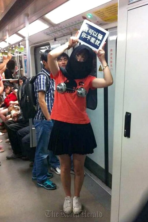 A woman holds a sign reading “I can be coquettish, but you can’t harass me” on Shanghai Metro Line 2.
A woman holds a sign reading “I can be coquettish, but you can’t harass me” on Shanghai Metro Line 2.