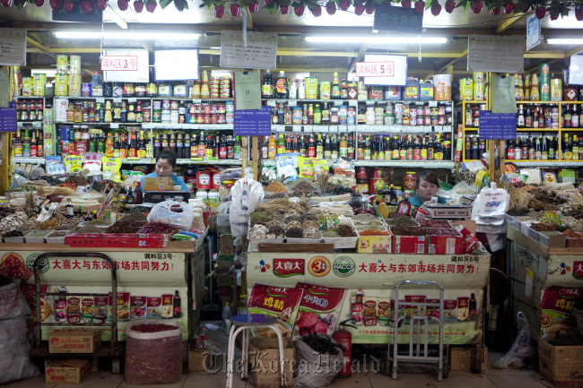 Vendors await customers in the dry goods section of a market in Beijing.  Bloomberg