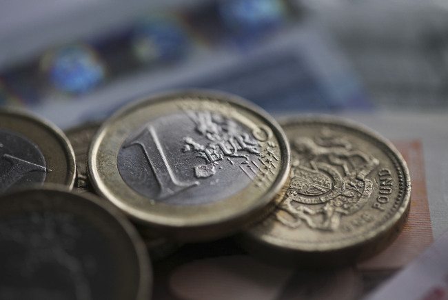 One euro and one pound coins sit on euro notes in this arranged photograph in London, U.K., on Friday, July 6, 2012. U.K. The euro may drop to the lowest level in more than three years against the pound, according to UBS AG, citing trading patterns. Photographer: Chris Ratcliffe/Bloomberg
One euro and one pound coins sit on euro notes in this arranged photograph in London.  Bloomberg