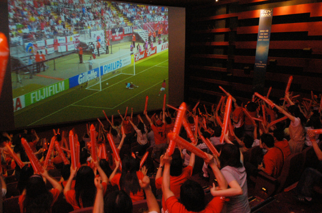 People watch a football game live on a full HD screen in one of the CGV theaters in Seoul. (CGV)