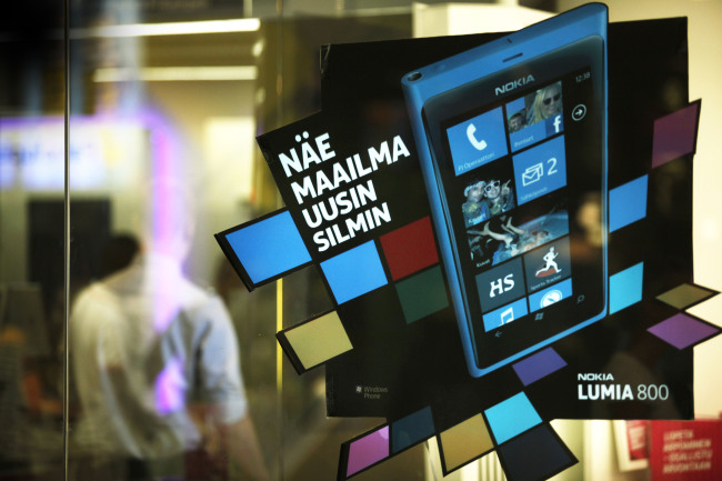 An advertisement for Nokia Lumia 800 smartphones sits on a window at a mobile phone store in Helsinki, Finland.  Bloomberg