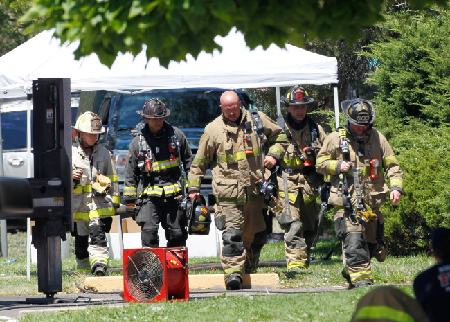 <YONHAP PHOTO-0207> Firefighters walk to shade as temperatures near 100 degrees, Saturday, July 21, 2012, at the booby trapped apartment of James Eagen Holmes, who police have identified as the suspect in the deadly shooting at a crowded movie theater a day earlier, in Aurora, Colo. Holmes has been charged in the shooting that killed 12 people and injured dozens more. (AP Photo/Ed Andrieski)/2012-07-22 07:25:51/ <저작권자 ⓒ 1980-2012 ㈜연합뉴스. 무단 전재 재배포 금지.>
Firefighters walk Saturday at the booby-trapped apartment of James Eagen Holmes, who police have identified as the suspect in the deadly shooting at a crowded movie theater a day earlier, in Aurora, Colorado.     AP-Yonhap News