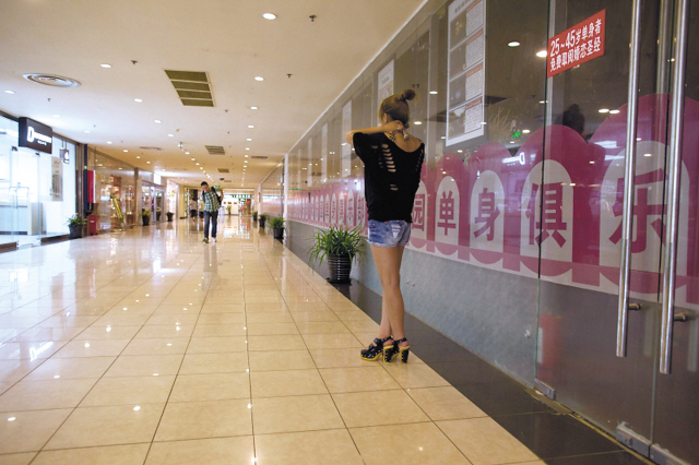 A woman stands outside a singles club in Beijing. (AFP)