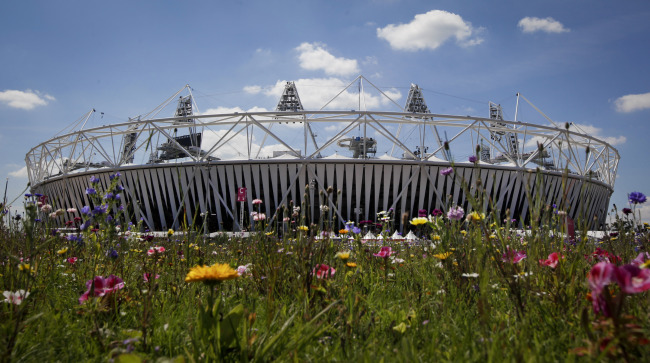 The Olympic Stadium is visible beyond an installation of artificial wildflowers in the Olympic Park for the 2012 London Summer Olympics on Sunday.  AP-Yonhap News