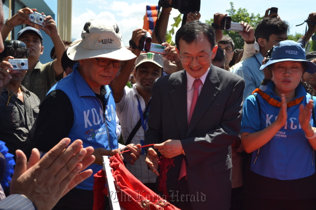 Korea International Cooperation Agency President Park Dae-won (left) and Seoul’s Ambassador to Nepal Kim Il-doo (second from right) put up a signboard at a ceremony to launch a technical college in Tamnagar, about 8 kilometers southeast of Katmandu, Saturday. KOICA