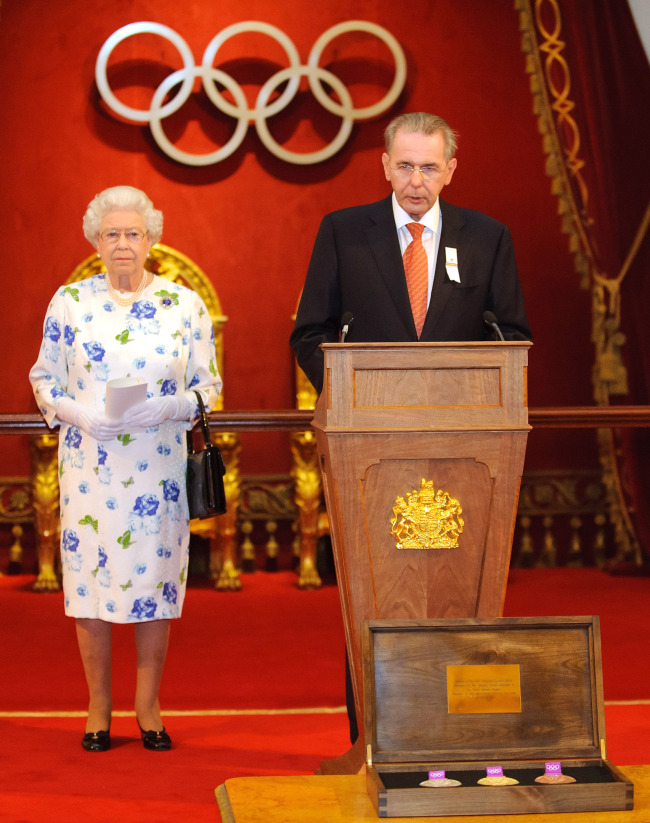 Queen Elizabeth II listens as IOC president Jacques Rogge speaks at Buckingham Palace on Monday.  AP-Yonhap News