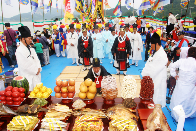 Elders of the town bow in front of an altar laden with ritual offerings to the Dragon King as they pray for the safety of fisherman. Beopseongpo Danoje, a traditional and cultural festival celebrated in the port town of Beopseongpo in South Jeolla Province, was designated as Important Intangible Cultural Asset No. 123 by the Cultural Heritage Administration on Tuesday.   Yonhap News