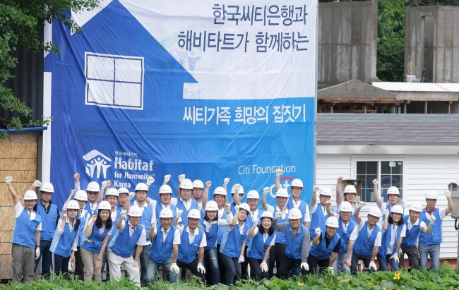 지난해 7월 경기도 양평 ‘희망의 집짓기’ 공사현장에서 하영구 은행장을 비롯한 한국씨티은행 임직원들이 화이팅을 외치고 있다. [사진제공=한국씨티은행]