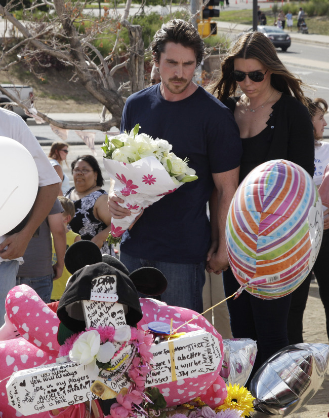 Actor Christian Bale and his wife Sibi Blazic carry flowers as they visit a memorial to the victims of Friday’s mass shooting in Aurora, Colorado on Tuesday.  AP-Yonhap News