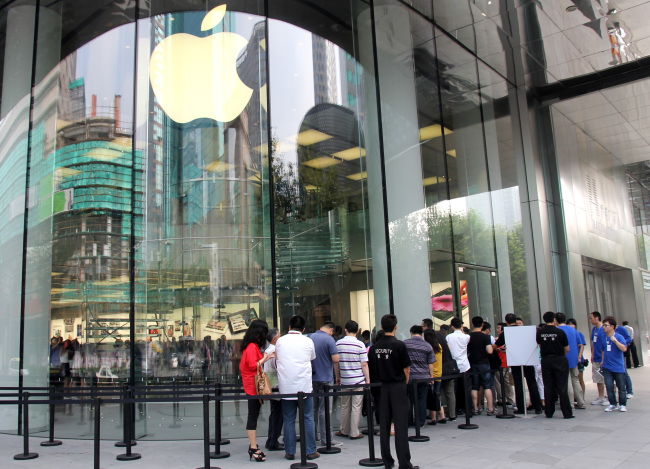 People queue up to purchase the New iPad at an Apple Store in Shanghai, China, Friday.   Xinhua-Yonhap News