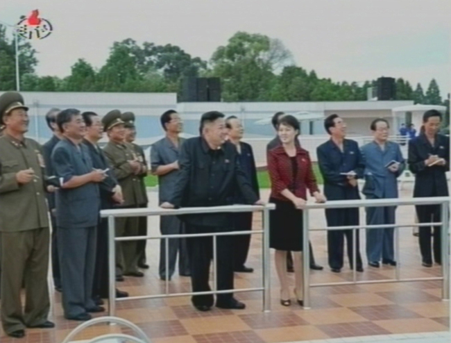 North Korean leader Kim Jong-un is accompanied by the woman speculated to be his wife as he inspects a park in Pyongyang in Korean Central News Agency footage aired on Wednesday.  Yonhap News