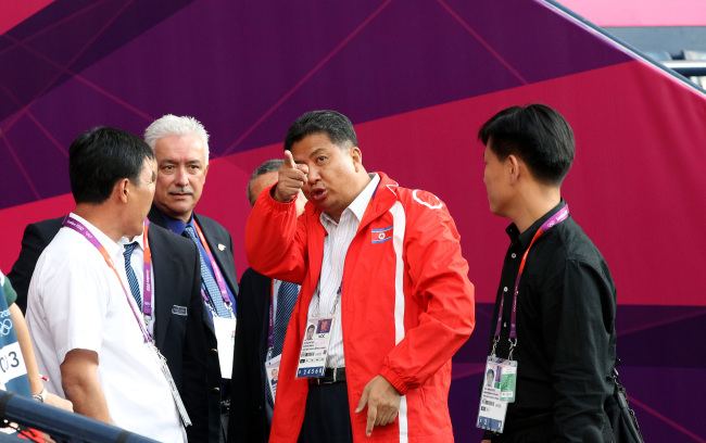 North Korean official Son Kwang-ho (center) speaks to Olympic officials during a soccer match delay between North Korea and Colombia on Wednesday.   AP-Yonhap News
