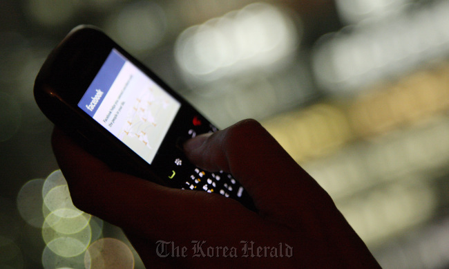 The Facebook Inc. website is displayed on a smartphone. Bloomberg