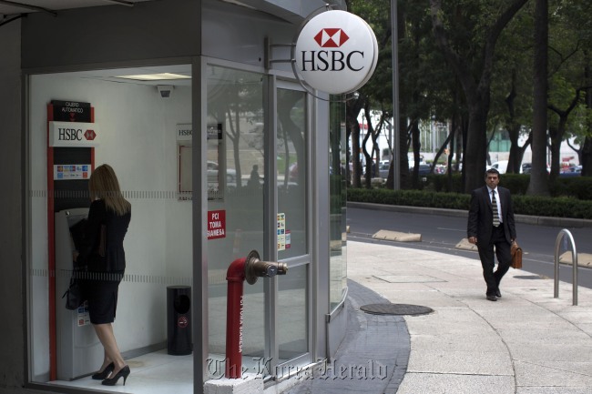 A woman uses a cash machine at the HSBC bank headquarters in Mexico City on Wednesday.   AP-Yonhap News