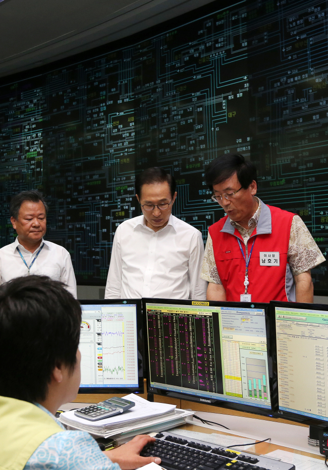 President Lee Myung-bak inspects the control center of the Korea Power Exchange in southern Seoul on Friday. At left is KEPCO CEO Kim Joong-kyum.   Yonhap News