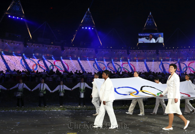 The Olympic flag is carried around the stadium during the Opening Ceremony at the 2012 Summer Olympics on Saturday in London.(AP-Yonhap News)