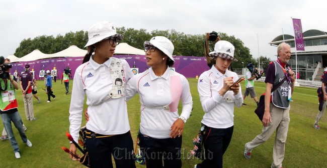 Three South Korean female archers cheer each other after the ranking rounds at the London Olympics on Friday. From left, Choi Hyeon-ju, Lee Sung-jin and Ki Bo-bae. (London Olympic Joint Press Corps)