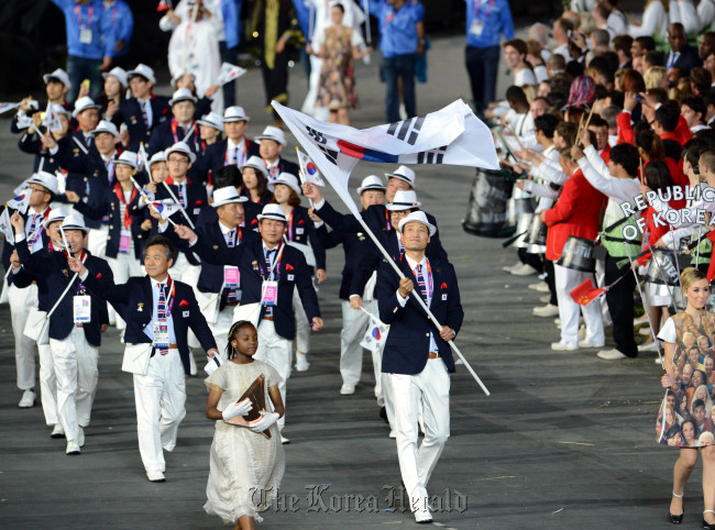 Handball player Yoon Kyung-shin carries the national flag at the opening ceremony of the London Olympics on Saturday, leading the 374-member South Korean delegation. (London Olympic Joint Press Corps)