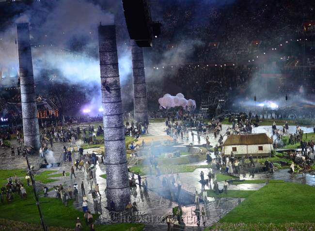 Actors perform around huge chimneys emerged from the ground to symbolise the industrial revolution during the opening ceremony of the London 2012 Olympic Games on Friday. (AFP-Yonhap News)