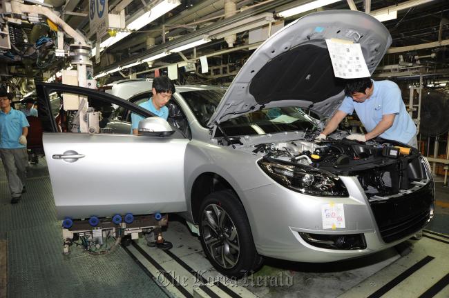 Workers go through final checks on an SM7 at Renault Samsung Motor’s factory in Busan.   RSM