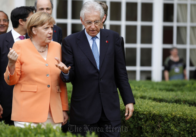 Angela Merkel (lef), Germany’s chancellor, walks in the garden with Mario Monti, Italy’s prime minister, after a joint news conference at Villa Madama in Rome on July 4.  Bloomberg