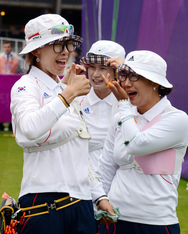 Choi Hyeon-ju (left), Ki Bo-bae (center) and Lee Sung-jin of South Korea celebrate after winning the women’s team archery final of the 2012 Olympic Games in London on Sunday.  London Olympic Joint Press Corps