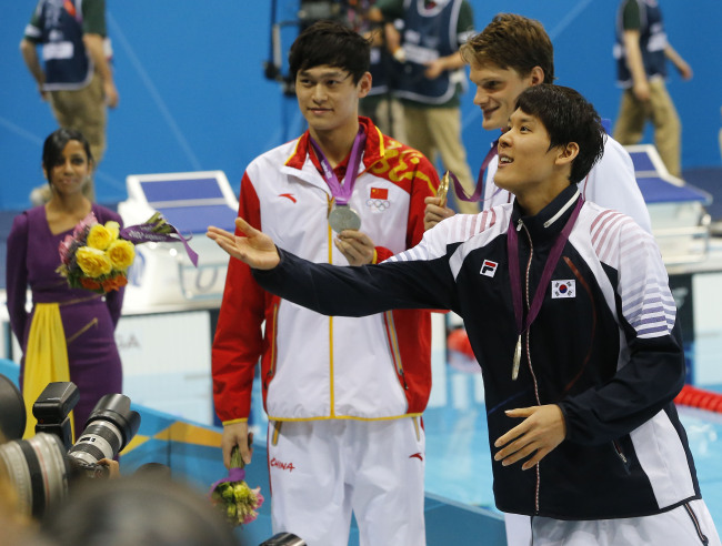Korean swimmer Park Tae-hwan throws a bouquet of flowers toward his mother after capturing the silver medal in the 200-meter freestyle on Monday.  London Olympic Joint Press Corps